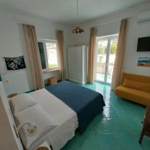 卡普里Villa del Sole的一间卧室配有一张床、一张沙发和窗户。