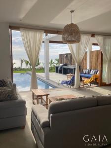 卡诺阿斯德蓬萨尔Casa GAIA - Punta Sal的带沙发和游泳池的客厅