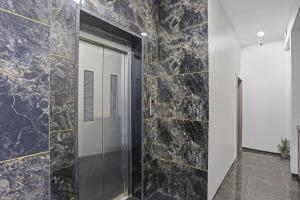 孟买Capital O Hotel Calista的带淋浴和黑色大理石墙壁的浴室