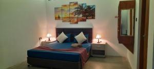 迪加纳Victoria Hideout的一间卧室配有一张带两盏灯的蓝色床。