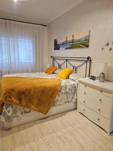 圣安东尼奥·德·卡隆Mar Vista的一间卧室配有一张带黄色枕头的床和梳妆台