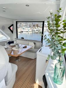 多维尔Puissance, Elegance et Style, Yacht à Deauville的一条带桌子和花瓶的船