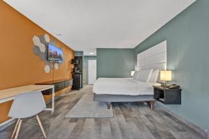 奇克托瓦加Buffalo Airport Hotel的一间卧室配有一张床、一张桌子和一把椅子