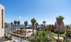 滨海罗克塔斯Apartamento El Castillo的享有棕榈树度假村和大海的景致。