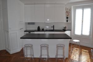 巴黎红磨坊二号公寓的厨房配有柜台和3个吧台凳