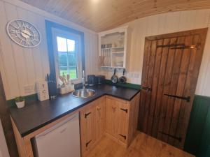 阿伯加文尼Cwtch Glamping Shepherds Huts的一个带水槽和木门的厨房