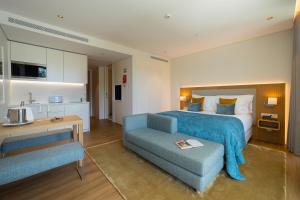 里斯本Martinhal Lisbon Oriente的酒店客房,配有床和蓝色的沙发