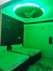 瓜廖尔OYO The Bliss Guest House & Restaurant的绿色的客房设有床和绿色的天花板