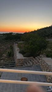 阿杰隆Chalets in the middle of Ajloun forests شاليه و مزرعة في وسط غابات عجلون的一套背面有日落的楼梯