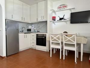 苏昂博Casa Peña en Son Bou的厨房配有白色橱柜和桌椅