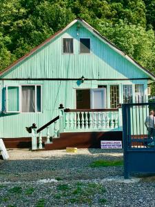 卡瓦拉提Green house in Gonio economy class的一座带门廊的蓝色房子,一个站在外面的人