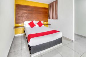 乔卢拉OYO Hotel Familiar Tollan的一间卧室配有红色枕头的床