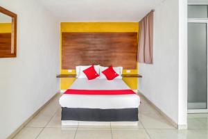 乔卢拉OYO Hotel Familiar Tollan的配有红色枕头的床的酒店客房