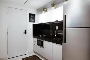 若昂佩索阿Unity - Cabo Branco的厨房配有白色橱柜和不锈钢冰箱