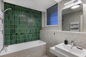 布达佩斯Florin Apart Hotel的一间带水槽、浴缸和镜子的浴室