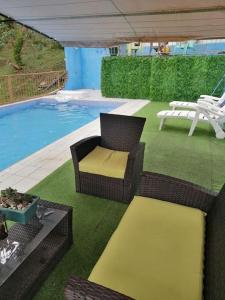 迦太基Quinta privada con cabaña y piscina temperada的一个带藤椅的庭院和一个游泳池