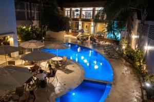 萨尔瓦多贝罗翁迪纳普拉亚酒店的享有带遮阳伞的游泳池的顶部景致
