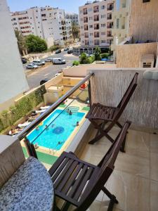 阿加迪尔弗卢列酒店的一个带两把椅子的阳台和一个游泳池