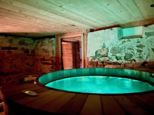 GsteigAlpen Charme - Chalet d'Hôtes et SPA的石墙房间内的热水浴缸
