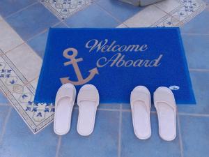 纳克索乔拉Yacht Marine Maison的地板上带一双鞋的迎宾板