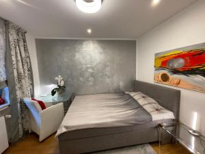 科隆Airport Rooms Waldblick的卧室配有一张床,墙上挂有绘画作品