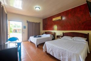 福尔图纳Hotel & Hot Springs Sueño Dorado的酒店客房设有两张床和窗户。