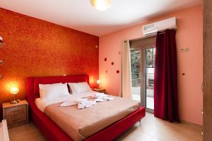Kalamitsi AmygdaliAnna Maria的一间卧室配有一张红色墙壁的床