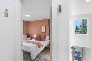 西雅图Elvis's Sweet Suite - 84 Walkscore的一间卧室配有带白色床单和粉红色枕头的床。