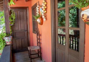 波拉-德拉维亚纳Casa Rural La Aldea的橙色的房子,有门和椅子