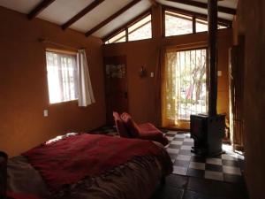 AlcoguazAlcohuaz Indomito的一间卧室配有一张床、一把椅子和窗户。