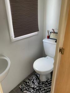 麦克尔斯菲尔德Monks Heath fold mobile home的浴室设有白色卫生间和黑板。