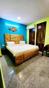 新德里Ms Residency的一间卧室,在蓝色的墙壁上配有一张大床
