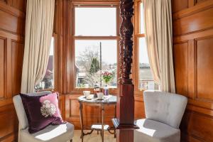 斯佩河畔格兰敦斯特拉撒伦住宿加早餐旅馆的客房设有桌子、两把椅子和窗户。