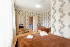 卡兹贝吉Hotel Garbani的一间设有两张床铺的卧室,位于带壁纸的房间