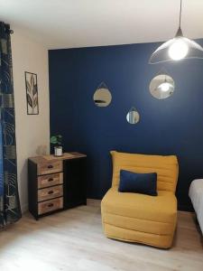 普里西尼Aux cocons Précignéens : Studio Bleuet的一间卧室配有黄色椅子和蓝色的墙壁