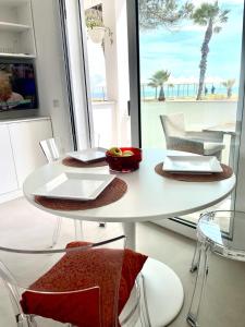 托里格兰德Windsurf Beach Front的白色的桌椅,享有海滩美景