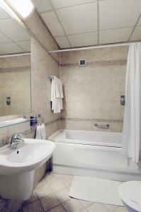 普雷绍夫杜克拉酒店的带浴缸、盥洗盆和卫生间的浴室