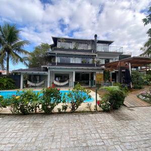 南圣弗朗西斯科Pousada Casa da Praia的一座房子前面设有游泳池