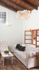 圣克里斯托瓦尔-德拉斯卡萨斯Noma Bed & Breakfast的客厅配有白色的沙发和桌子