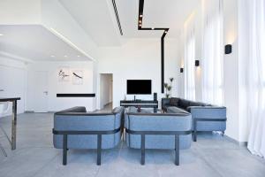 内坦亚Luxury Penthouse in Netanya的客厅配有蓝色椅子和沙发