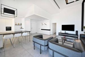 内坦亚Luxury Penthouse in Netanya的客厅配有沙发和桌椅