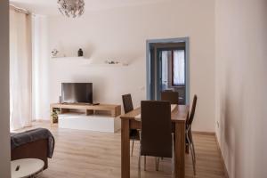 莱里奇Appartamento con parcheggio e Aria Condizionata的一间带桌子和电视的用餐室