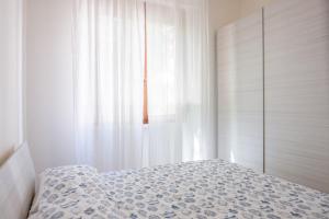 莱里奇Appartamento con parcheggio e Aria Condizionata的一间卧室设有一张床和一个窗口