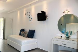 帕尔加Dafni studios no6的白色的客房配有白色的沙发和镜子