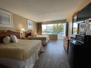 默特尔比奇Polynesian Oceanfront Hotel的酒店客房设有两张床和一个阳台。