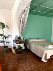 明图尔诺CasaMoltoCarina Cottage Garden的一间卧室配有一张床和一张植物桌子