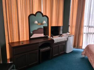 苏克雷格洛列塔酒店的一间卧室配有一张带镜子的书桌