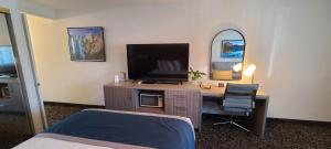 隆派恩陶别墅汽车旅馆的一间卧室配有一张桌子、一台电视和一张床