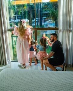 伊瓜苏维瓦卡塔瑞斯度假酒店的男人和两个孩子在窗前玩娃娃
