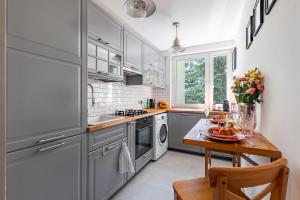 华沙Secret Garden Apartment的厨房配有灰色橱柜和水果桌
